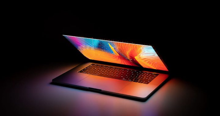 A sleek laptop with a vibrant display against a dark background.